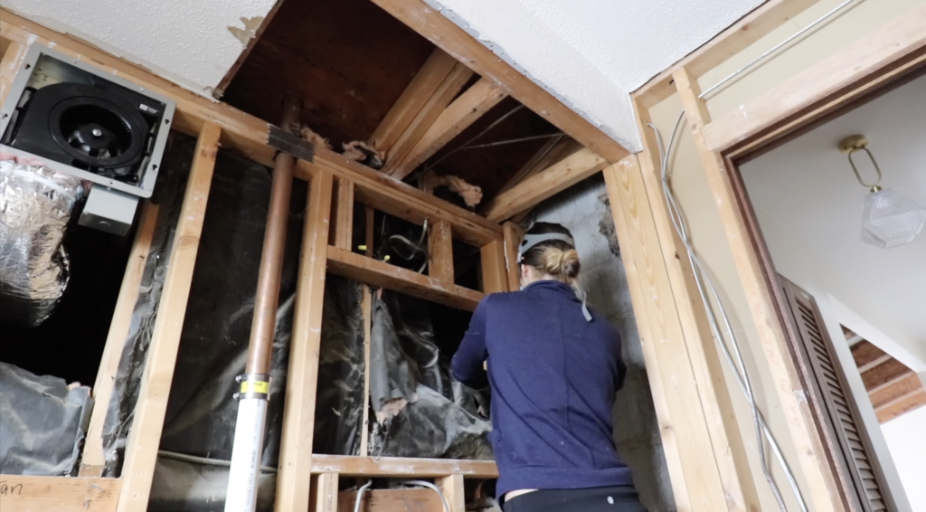 pushing the existing insulation into the wall to make space for the new 